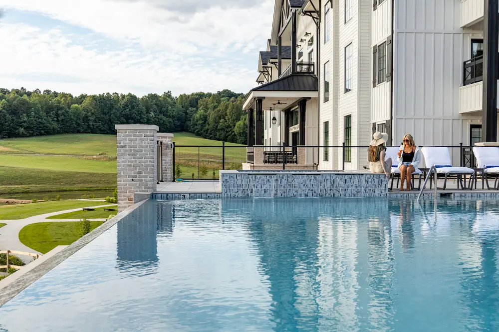 women lounging next to pool